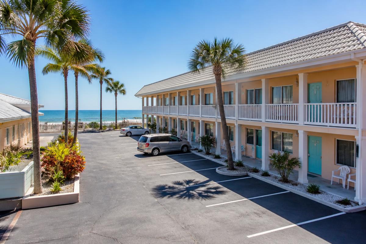 Traditional Florida beachside motel with palm trees and ocean view
